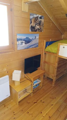 a room with a bed and a television in a cabin at Chalet Les Hautes Cimes in Châtel