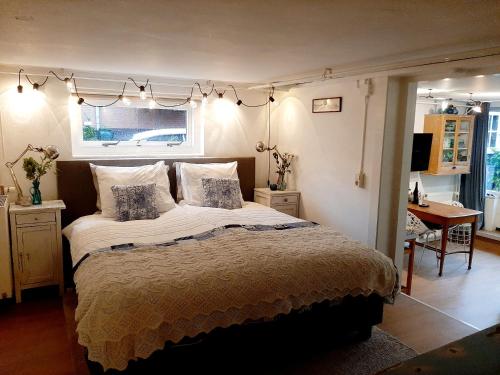 a bedroom with a large bed with lights above it at Gezellig souterrain in bollestreek met prive ingang in Hillegom