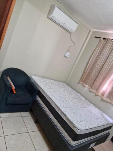a bed and a chair in a room at Quadra 6 Paiaguás Parque das Águas Cuiabá in Cuiabá