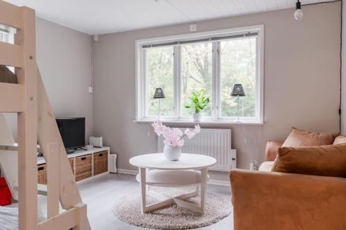 a living room with a table and a couch at Green Villa in Tjörnarp
