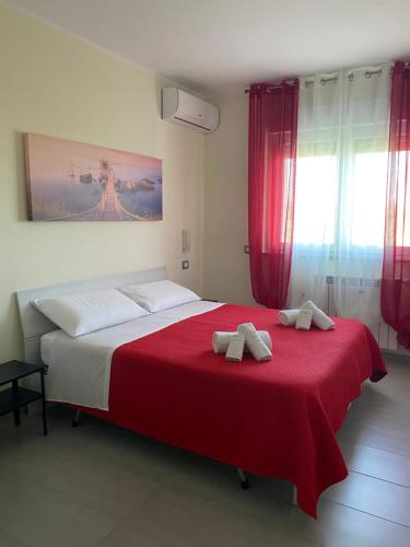 a bedroom with a red bed with two towels on it at Colline del sole in San Salvo