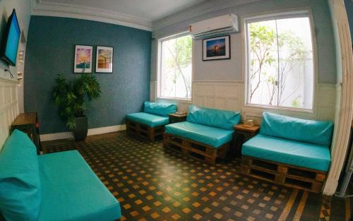 a waiting room with blue chairs and windows at Mango Tree Ipanema in Rio de Janeiro