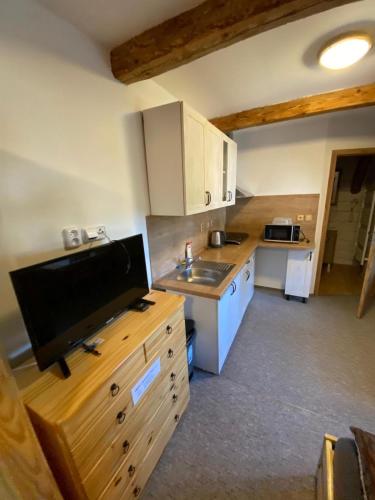 a kitchen with white cabinets and a counter top at Apartmán na statku Červený Kostelec in Červený Kostelec