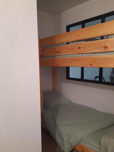 une chambre avec un lit superposé et une fenêtre dans l'établissement Le Lioran, à Le Lioran
