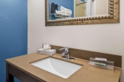 a bathroom with a sink and a mirror at Sonesta Essential IAH Airport JFK Boulevard - Newly Renovated in Houston