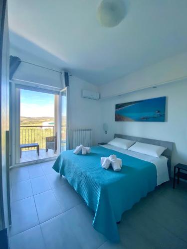 a bedroom with a blue bed and a large window at Colline del sole in San Salvo