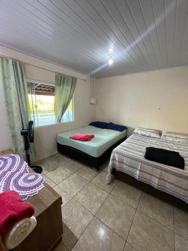 a bedroom with two beds and a window at Casa gravata de penha in Penha