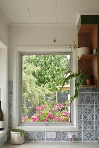 a window in a kitchen with flowers in a garden at Evendale House in Hastings