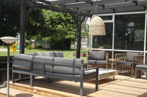 a patio with a couch and chairs on a deck at Evendale House in Hastings