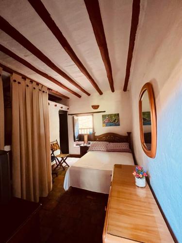 a bedroom with a bed and a table in a room at Posada Altagracia San Gil in San Gil