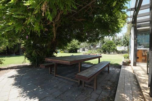 a picnic table and a bench under a tree at Evendale House in Hastings