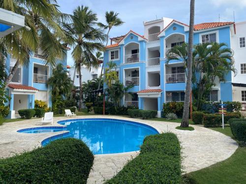 un complexe avec piscine et palmiers dans l'établissement Paradise Arenas De Bávaro RD, à Punta Cana
