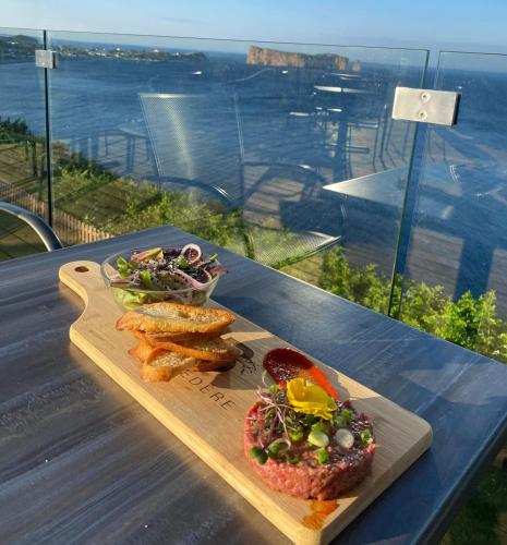 a plate of food on a table with a salad at Hôtel La Côte Surprise in Perce