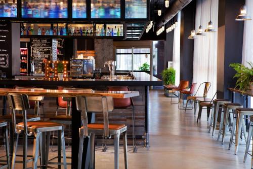 a bar in a restaurant with tables and chairs at MOXY New Orleans Downtown/French Quarter Area in New Orleans