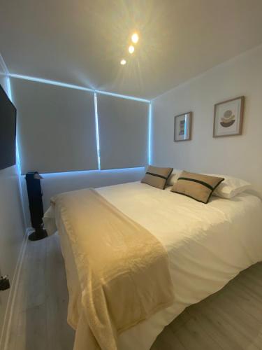 a bedroom with a large white bed in a room at Kennedy Premium Apartments Colorado in Santiago