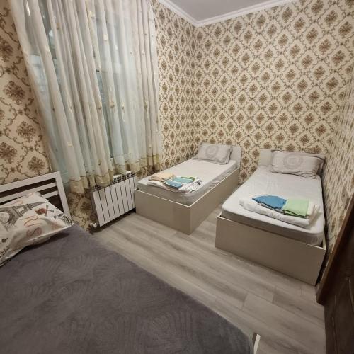 a bedroom with two beds and a window at Aviacity Apartment in Baku