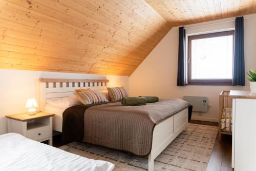 a bedroom with two beds and a wooden ceiling at Chalet Laura in Stará Lesná