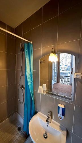 une salle de bain avec un lavabo, un miroir et une douche dans l'établissement Grand Hôtel De L'Europe, à Paris