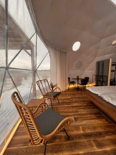 a room with chairs and a bed and a window at Glamping Liptov in Liptovský Trnovec