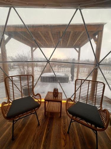 two chairs and a table in front of a window at Glamping Liptov in Liptovský Trnovec