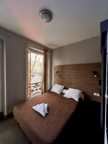 une chambre avec un grand lit avec deux serviettes dessus dans l'établissement Grand Hôtel De L'Europe, à Paris