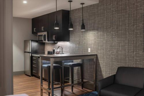 a kitchen with a bar with stools and a counter top at Residence Inn by Marriott Manchester Downtown in Manchester