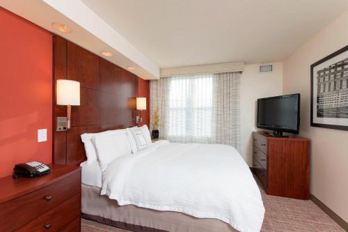 a bedroom with a bed and a flat screen tv at Residence Inn Moline Quad Cities in Moline
