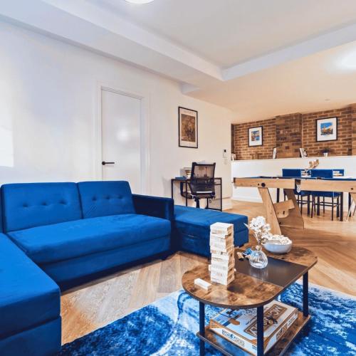 a living room with a blue couch and a table at Signature Suite- City Centre, Pool Table, Canal, Netflix Sleeps 7 in Birmingham