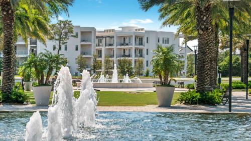 a fountain in front of a building with palm trees at Mistral 10 in Seacrest