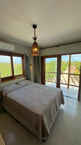 a bedroom with a large bed and a chandelier at Casa AL Mar - Praia do Preá in Prea