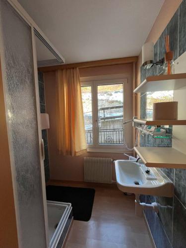 a small bathroom with a sink and a window at Hotel Rhoneblick in Guttet-Feschel