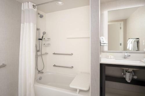 a white bathroom with a tub and a sink at Residence Inn by Marriott Modesto North in Modesto