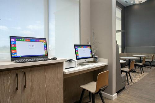 a office with two computers on a counter with chairs at Residence Inn by Marriott Modesto North in Modesto