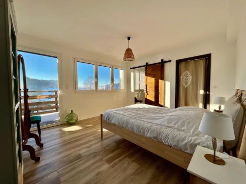 une chambre avec un lit et une table avec une lampe dans l'établissement Le Grand Palatinat - Prestige & vue panoramique lac, à Gérardmer