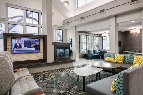 a lobby with couches and a flat screen tv at Residence Inn by Marriott Lincoln South in Lincoln