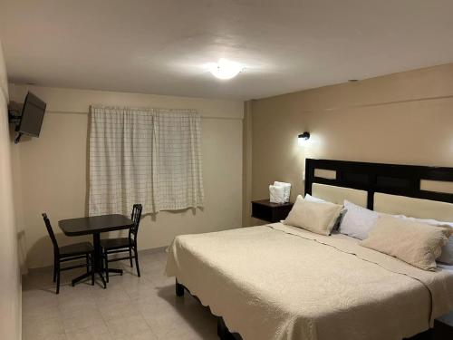 a bedroom with a bed and a table and a window at HOTEL GOLD in El Oro de Hidalgo