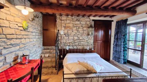 a bedroom with a bed and a brick wall at La Valle Del Sole Country House in SantʼIppolito