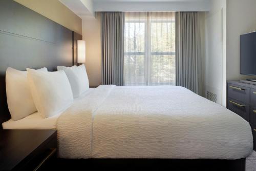 a hotel room with a large bed and a window at Residence Inn by Marriott Covington Northshore in Covington