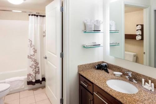 a bathroom with a sink and a toilet and a mirror at Residence Inn Jackson Ridgeland in Ridgeland