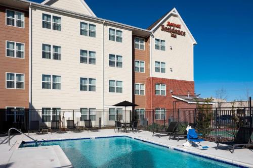 a person walking by a pool in front of a hotel at Residence Inn Jackson Ridgeland in Ridgeland