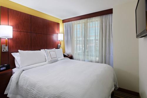 a bedroom with a white bed and a window at Residence Inn by Marriott Little Rock Downtown in Little Rock