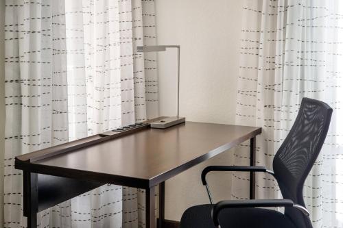 a desk with a chair in front of a curtain at Residence Inn San Diego La Jolla in San Diego