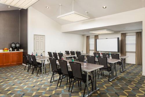 a conference room with tables and chairs and a screen at Residence Inn San Diego La Jolla in San Diego