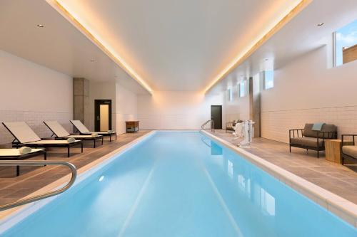 a large swimming pool with chairs and a swimming pool at Residence Inn by Marriott Missoula Downtown in Missoula