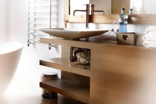 a bathroom with a sink on a wooden shelf at Boutique hotel Urbisol in Calders