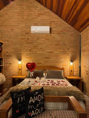 a bedroom with a bed in a brick wall at Chalés Brisa Da Montanha in Sapucaí-Mirim