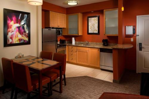 a kitchen with a table and chairs in a room at Residence Inn Melbourne in Melbourne