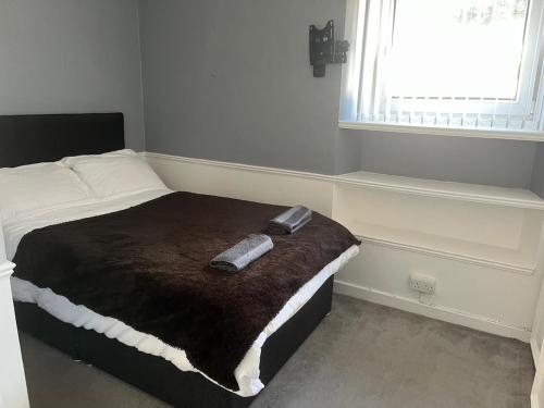 a bedroom with a bed with a remote control on it at R&Gs in Aber-fan