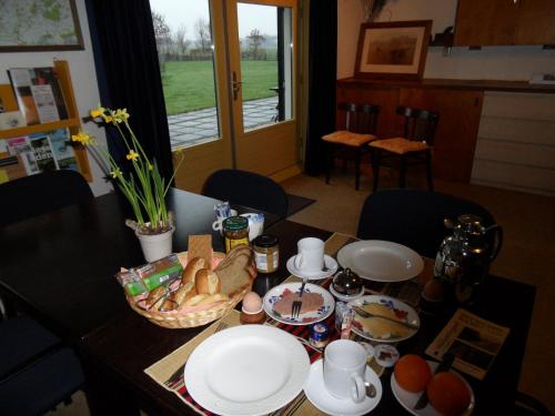 una mesa con platos de comida encima en Logeren bij de Ruimte, en Nijeholtpade