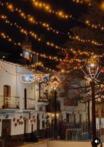 a building with christmas lights hanging from it at Alojamiento La Fuente in Fuenteheridos